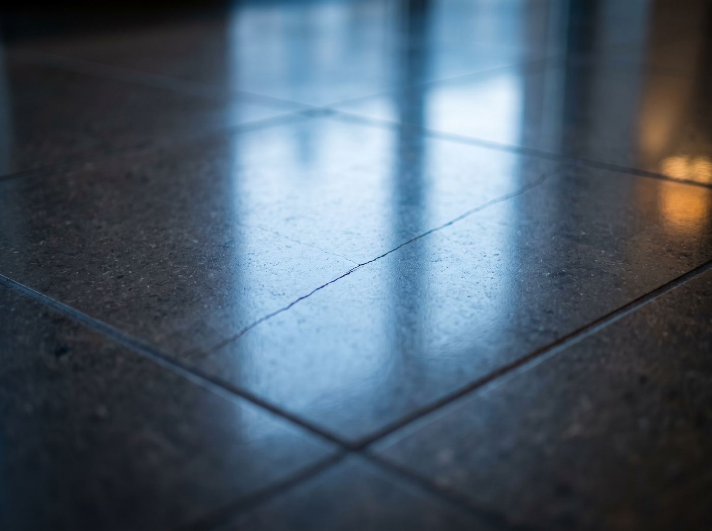 A hairline crack across a polished lobby floor tile
